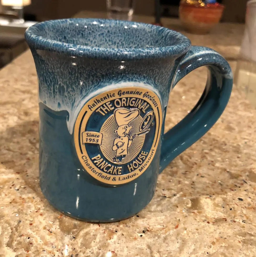 A blue coffee mug with the seal of the united states coast guard on it.
